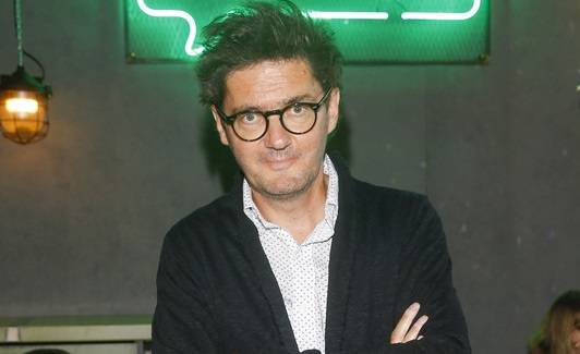 Kuba Wojewódzki na zdjęciu sprzed lat. Dziennikarzowi towarzyszą niemal nagie kobiety